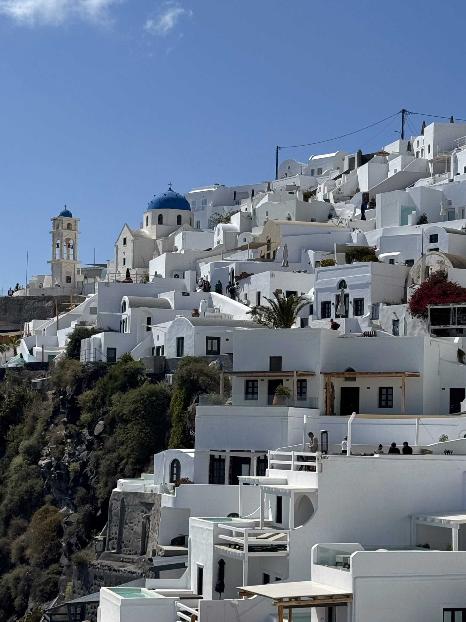 IMG_9368 Imerovigli looking up resized - Taussig Travel White-washed hillside village with blue-domed church and terraces, Santorini under a clear blue sky